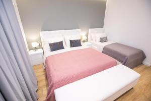 two beds in a small room with white walls at Hotel Elior in Tirana