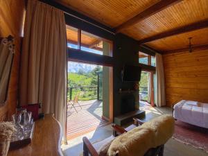 a room with a living room with a fireplace and a bedroom at Cabana Mantiká in Sapucaí-Mirim