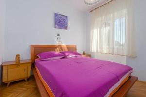 a bedroom with a large bed with a purple blanket at Apartment Lili in Umag +22 photos