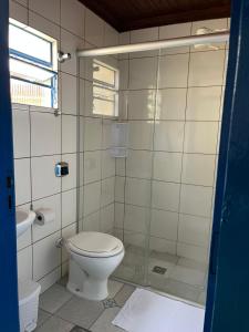 a bathroom with a toilet and a glass shower at Cantinho dos Berens in Diamantina +11 photos