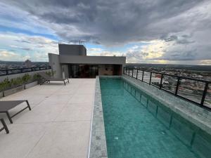 a building with a swimming pool on top of a building at Studio Cuiabá NOVO - Frente ao Shopping Estação in Cuiabá