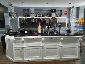 a large white bar with a lot of alcohol at THE COASTAL INN ACCOMMODATIONs in Cellardyke
