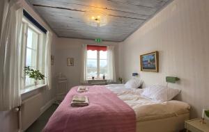 una camera da letto con un grande letto con una coperta rosa di Osaby Säteri a Tävelsås