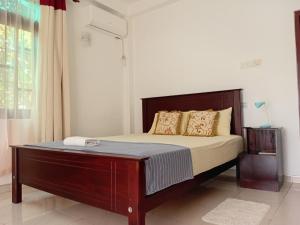 a bedroom with a bed with a wooden headboard at Lake Life Villa in Ambalangoda