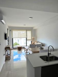 cocina y sala de estar con fregadero y sofá en Caleta Centro Madryn, en Puerto Madryn