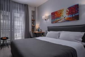 a bedroom with a bed and a painting on the wall at Galleries Elegant Suites in Thessaloniki