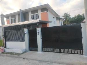 a house with a black gate in front of it at Casa de Ligaya San Pablo in San Pablo