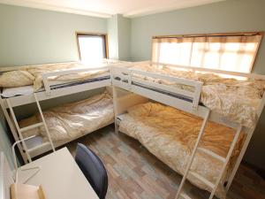 2 literas en una habitación con mesa en 東京の中心地 Okachimachi Staypia, en Tokio