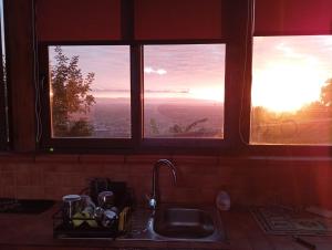 a kitchen with a sink and two windows with the sunset at Casetta del Borgo in Lamezia Terme +51 photos