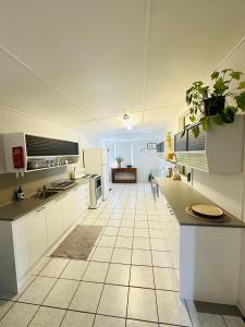 Il comprend une grande cuisine avec des placards blancs et du carrelage. dans l'établissement Cottage on the Bay, à Sandgate