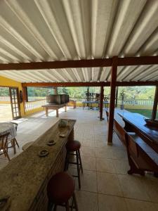 a patio with a large wooden table and chairs at Sítio Mairiporã-Piscina Aquecida in Mairiporã