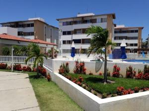 a resort with a swimming pool and palm trees and buildings at Comfortable apartment in Barra dos Coqueiros
