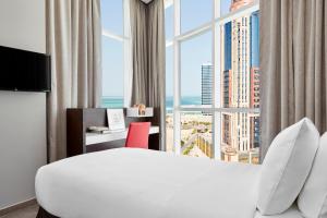 A bed or beds in a room at Staybridge Suites - Doha Lusail by IHG