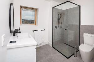 a bathroom with a shower and a sink and a toilet at Avonside Alpine Estate - Jindabyne in Coolamatong +12 photos