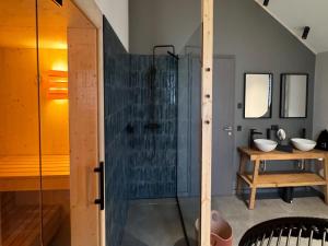 a bathroom with a shower and two sinks in it at modernes Chalet in Hahnenklee in Hahnenklee-Bockswiese +23 photos