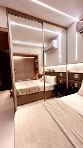 una camera da letto con due letti e uno specchio di LOFT de Luxo - COP30 a Belém