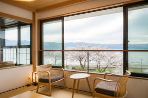 諏訪市にある寛ぎの諏訪の湯宿　萃sui‐諏訪湖の桜の景色を望む窓付きの客室です。