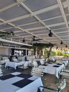 a restaurant with white tables and white chairs at Seaview Regency Tanjung Tuan Apartment A7-4 in Pulau Burung