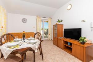 a dining room with a table and a television at Apartments with parking space Punat, Krk - 20553 in Punat