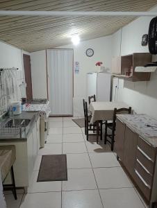 a kitchen with a table and a table and chairs at Cantinho do lar in Timbó +16 photos