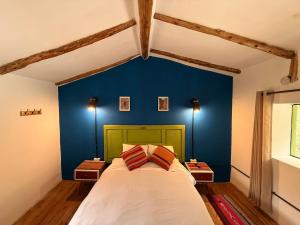 una camera da letto con una parete blu e un letto di Anido Hotel a Ollantaytambo