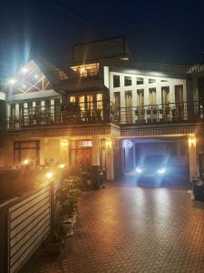 シロンにあるSamanbha Guest Houseの夜間の家の前に停車する車