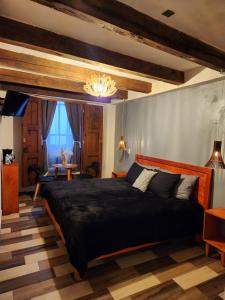 ein Schlafzimmer mit einem großen schwarzen Bett und einem Tisch in der Unterkunft Piedra Negra Boutique Hotel in San Cristóbal de las Casas