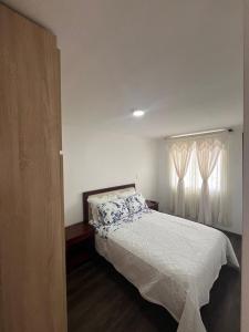 un dormitorio con una cama y una ventana en Conjunto Residencial Ambar Reserva, en Armenia