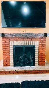 a fireplace with a tv on top of it at Cantinho Dona Cleide in Monte Verde +79 photos