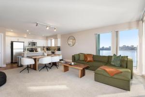 a living room with a green couch and a kitchen at Charming Bliss By the Ocean LUXE 2bd 2ba MDR in Los Angeles