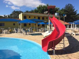 a red slide in front of a swimming pool at Hotel Fazenda Pé da Serra in Bom Sucesso