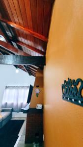 a wall with a sign on the side of a room at Cantinho Dona Cleide in Monte Verde