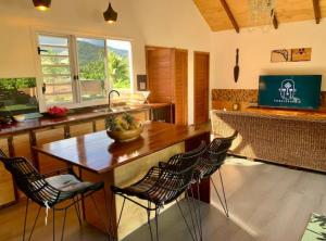 eine Küche mit einem Holztisch und Stühlen in der Unterkunft Holiday house Nuupure - Accès plage privée & terrain de Pickelball in Maatea