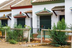 una casa con persianas verdes y una valla en Casa Rural Los Pinos, en Hinojos