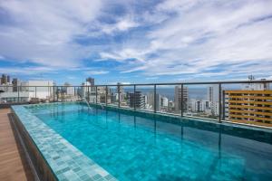 a swimming pool on the roof of a building at Studio Barra Concept in Salvador