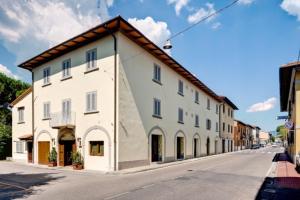 un grand bâtiment blanc sur le côté d'une rue dans l'établissement Hotel Il Cavallo, à Barberino di Mugello