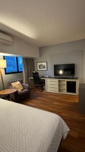 Habitación de hotel con cama, escritorio y TV. en M N Flats - Quarto Dentro Do Hotel WB WTC Berrini, en São Paulo
