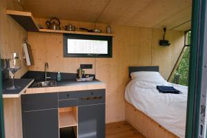 a small kitchen with a bed in a tiny house at Sleep Space 35 - Green Tiny Village Harz in Osterode