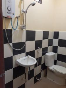 a bathroom with a toilet and a sink at Four F Motel by Lily in Pantai Cenang
