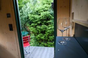 two wine glasses sitting on a table in front of a window at Sleep Space 28 - Green Tiny Village Harz in Osterode +36 photos