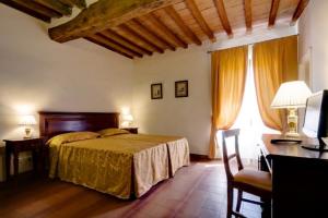1 dormitorio con 1 cama y escritorio con ordenador en Hotel Il Cavallo en Barberino di Mugello