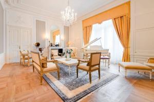 a living room with a table and a piano at Hotel Bristol, A Luxury Collection Hotel, Warsaw in Warsaw