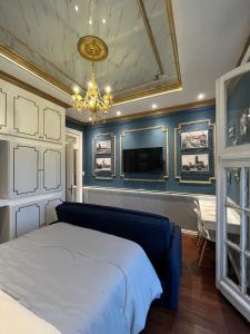 a bedroom with blue walls and a bed and a chandelier at Salvo 1928 in Montevideo
