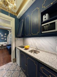 a kitchen with blue cabinets and a sink at Salvo 1928 in Montevideo +33 photos