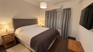 a small bedroom with a bed and a window at Vista Montañas y Viñas in Cafayate +22 photos