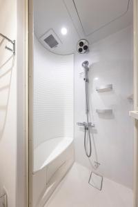 a white bathroom with a shower and a tub at WeBase KAMAKURA in Kamakura