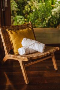 a wicker chair with two towels and a pillow at Port Douglas Alamanda Estate w Ocean Views & Pool in Craiglie