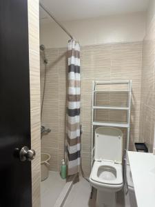 a bathroom with a toilet and a shower at D&G City Haven in Mandaue City
