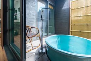 a bath tub in a room with a chair at 谷町君 星屋 神泉ノ宿 二条城 in Kyoto