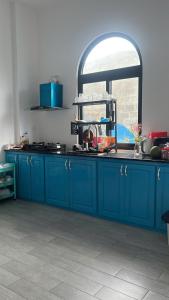 a kitchen with blue cabinets and a window at Dứa Homestay in Cu Lao Thu